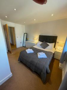 吉尔福德Blue Sky Apartments@ Abbots Yard, Guildford的一间卧室配有一张大床和两条毛巾