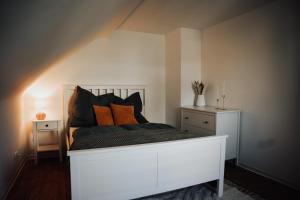 拉姆斯泰因-米森巴赫Offenes Stilvolles Stadthaus的客房内的白色床和橙色枕头