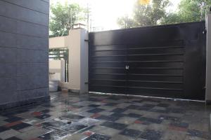 拉合尔Vacation Villa的黑色车库门,铺着 ⁇ 格的瓷砖地板