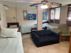 普拉亚科罗纳多Coronado Beachfront tropical home!的一间带两张床和一张沙发的客厅