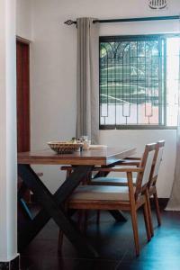 阿鲁沙Tropicana House的一张带两把椅子的木桌和窗户