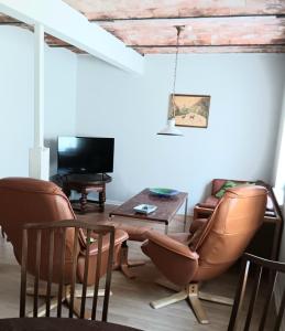 GørdingBøelgaarden的客厅配有两把椅子、一张桌子和电视
