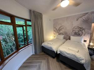 开普敦WunderLux的一间卧室设有两张床,并拥有植物壁画