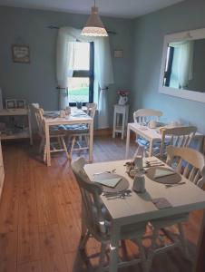 凯尔斯Loughcrew View Bed and Breakfast的一间带桌椅的用餐室和窗户。
