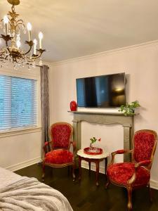 多伦多市中心维多利亚式豪华疗养旅馆的一间卧室配有两把椅子、一张桌子和一台电视。