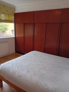 磨坊山2 Bed Mill Hill Flat的一间卧室配有一张大床和木制床头板