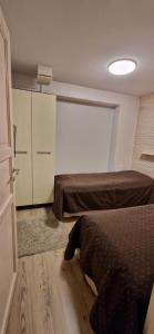 基蒂莱Levin Kolmio C4的一间卧室设有两张床、一个衣柜和一扇门。