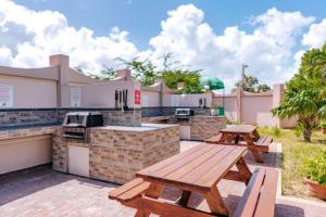 棕榈滩加勒比棕榈度假酒店的庭院设有两张野餐桌和烧烤架。