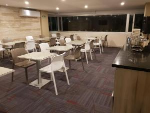 辛塞莱霍Hotel Arawak Plaza的一间带桌椅的用餐室和一间酒吧