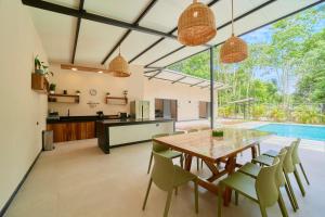 卡维塔LaLola Villa Privada的开放式厨房以及带木桌和椅子的用餐室。