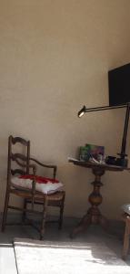 索维拉Tigmi Anis的一间带椅子和一张桌子及台灯的房间