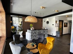 文盖尔斯卡－古尔卡WRZOS resort & wellness的客厅配有黄色椅子和桌子