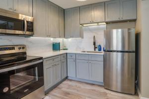 明尼阿波利斯Cozy Minneapolis Duplex - 10 Mi to Downtown!的厨房配有白色橱柜和不锈钢冰箱