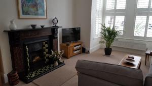 普里茅斯Beautiful Victorian Home的客厅设有壁炉和电视。