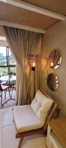 巴纳内拉斯Flat dos Sonhos Bananeiras的客厅配有椅子和镜子