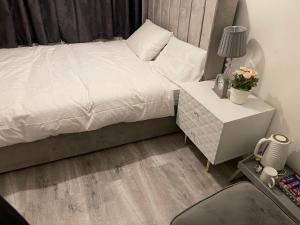 伦敦Divine Room的卧室配有白色的床和带床头柜的卧室