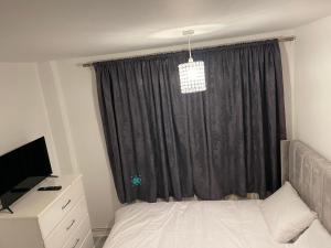 伦敦Divine Room的一间卧室配有床和黑色窗帘