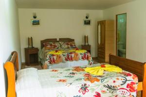 安加罗阿Hostal y Cabañas Aorangi的一间卧室配有两张床和镜子