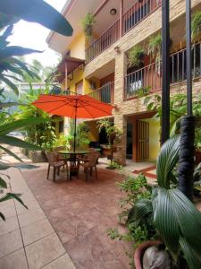 曼努埃尔安东尼奥Hotel Villa Prats的庭院配有橙色雨伞和桌椅