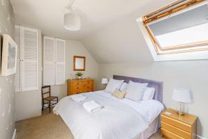 柯库布里The Cheeseloft - Spacious one bed with terrace的一间卧室配有一张带白色床单的床和一扇窗户。