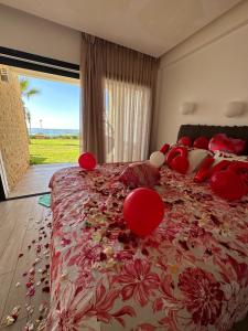西迪布克纳德尔OCEAN VIEW, Prestigia Plage des Nations的一间卧室配有一张带红色枕头的大床