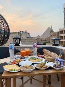 开罗Locanda Pyramids Hotel的阳台上摆放着食品和饮料的桌子