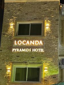 开罗Locanda Pyramids Hotel的建筑一侧的酒店标志