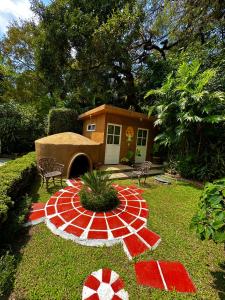 迪坡斯特兰BUNGALOWS ANDREA的一座小房子,花园内有红色和白色的图案