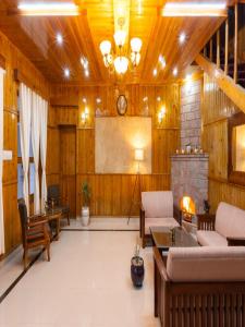 奈尼塔尔The Manora Woods Resort - Private Hill Top, Gethiya, Nainital的一个带壁炉和屏幕的大客厅