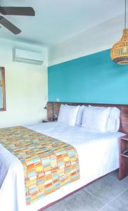 福尔图纳La Fortuna Lodge by Treebu Hotels的一间卧室设有一张蓝色墙壁的大床