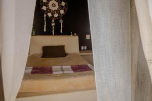 特隆戈内斯Casa Jasmin Bed & Breakfast的一间带一张床和吊灯的小卧室