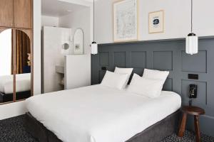 里昂Hotel De Verdun 1882, BW Signature Collection的卧室配有白色大床和白色枕头