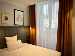 里昂Hotel De Verdun 1882, BW Signature Collection的卧室配有白色的床和窗户。