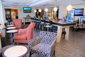 橙县奥兰治希尔顿恒庭酒店的餐厅内的酒吧,配有桌椅