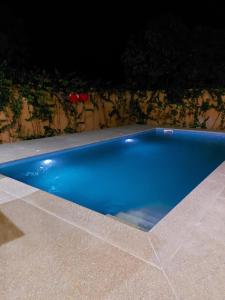 索蒙Villa Somone 4 chambres avec Piscine的夜晚后院的蓝色游泳池