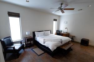 休斯顿Casablanca 1的一间卧室配有一张带吊扇和椅子的床