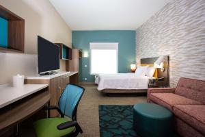 普弗拉热维尔Home2 Suites by Hilton Pflugerville, TX的酒店客房设有一间带一张床和一张沙发的卧室
