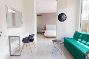 波哥大ESPECTACULAR APTO CON EXCELENTE VISTA EN CHICO的客厅配有绿色沙发和床。