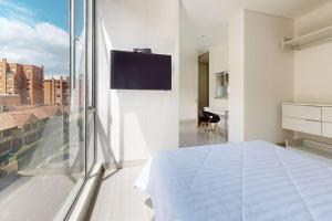 波哥大ESPECTACULAR APTO CON EXCELENTE VISTA EN CHICO的一间卧室设有一张床和一个大窗户