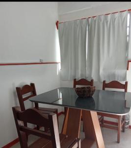 卡梅隆Apartamento amueblado en Carmelo con aire acondicionado的餐桌,椅子和碗
