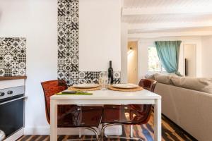 圣巴托洛梅Lodge Nature in quiet Montain - Private Jaccuzi and garden, Wifi - La Lézardière的厨房以及带白色桌椅的起居室。