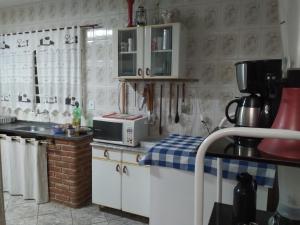 索科罗Chácara meu doce的厨房配有白色橱柜和微波炉