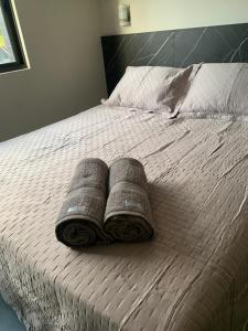 若昂佩索阿Arpoar Suítes Hotel Unidade 120的一张带两个枕头的床和一本书