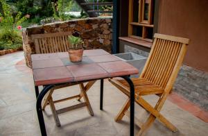 CarhuazFleur Lodge的一张桌子,上面有两把椅子和盆栽植物