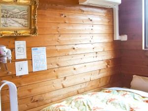 山中湖村Minamitsuru-gun - Hotel / Vacation STAY 45535的一间卧室设有木墙,配有一张床