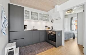 古兹耶姆Stunning Apartment In Gudhjem With Wifi的一间厨房,配有白色的橱柜和一张位于客房内的床