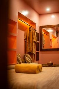 金巴兰VA Villa Jimbaran Bali的一间设有一张带镜子和浴袍的床的房间