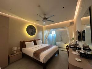 龙川市Phuong Nam Hotel An Giang的一间卧室配有一张床和一张带吊扇的书桌