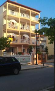 奥林匹亚基·阿克蒂玛丽克莱尔一室公寓的带阳台的建筑,前面设有停车场