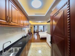 广州广州志诚领游国际公寓的一个带水槽的厨房和一张位于客房内的床